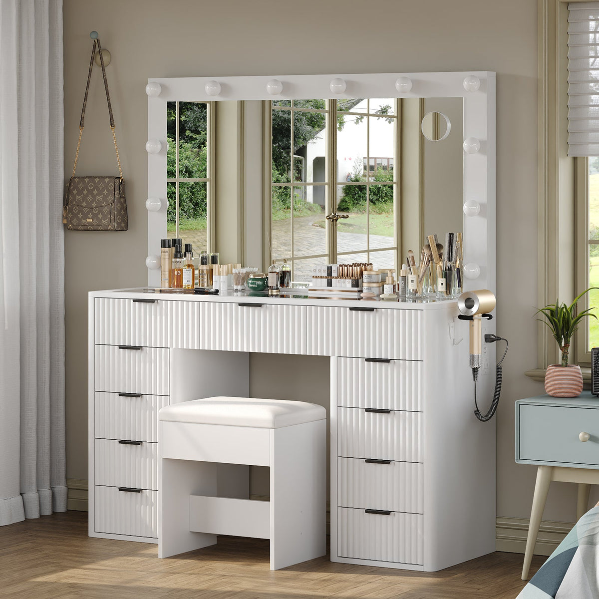 White fluted vanity desk with lighted mirror and matching stool in a bedroom